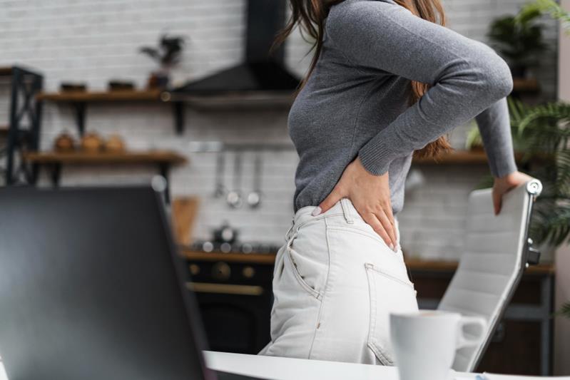 woman having a backache while working from home