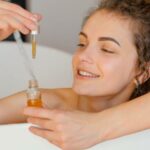 woman relaxing in bathtub with serum