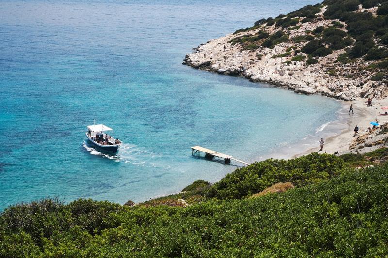 aerial photography shot of a boat approaching the beach in Amorgos Greece