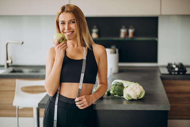 young woman with measuting tape at the kitchen