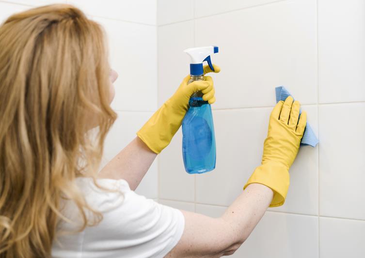 woman cleaning the shower wall