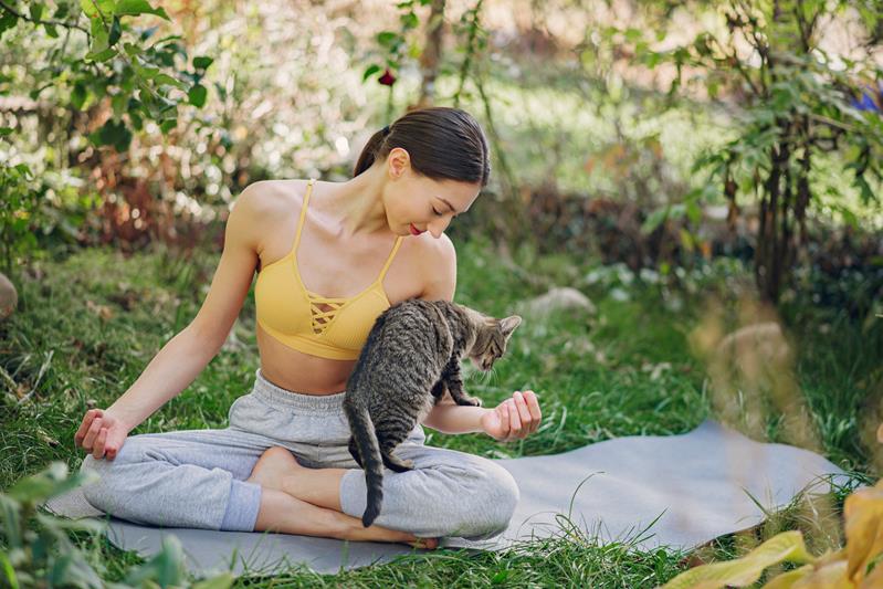 girl sitting in a summer park with cute cat