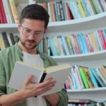 portrait of focused man in-glasses reading book