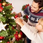 A person decorating an eco-friendly Christmas tree