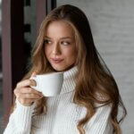 A slim woman holding a cup of coffee